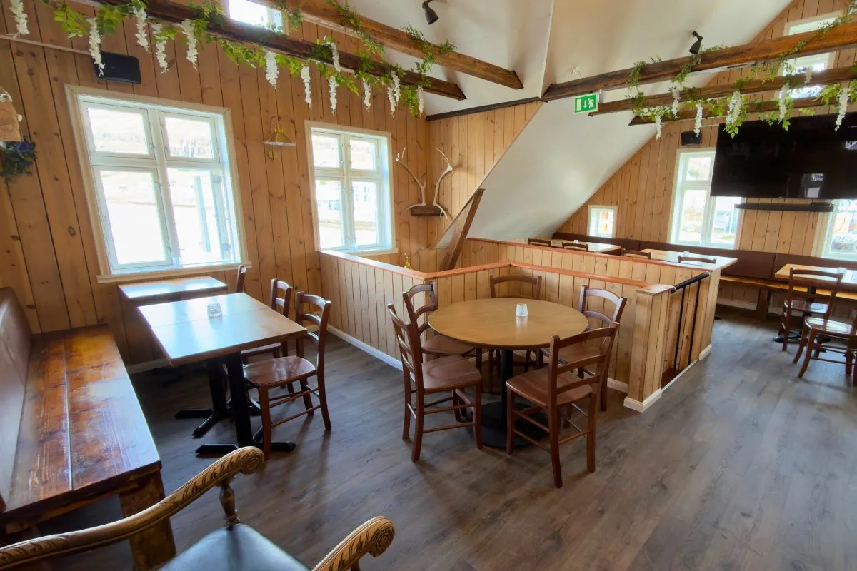 Cozy wooden interior dining room of Kaffi Lára El Grillo Bar in Seyðisfjörður.