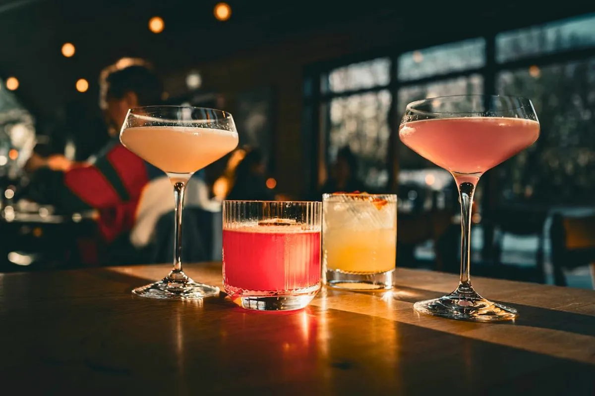Selection of colorful craft cocktails on a wooden table at LYST café and bar in Akureyri.