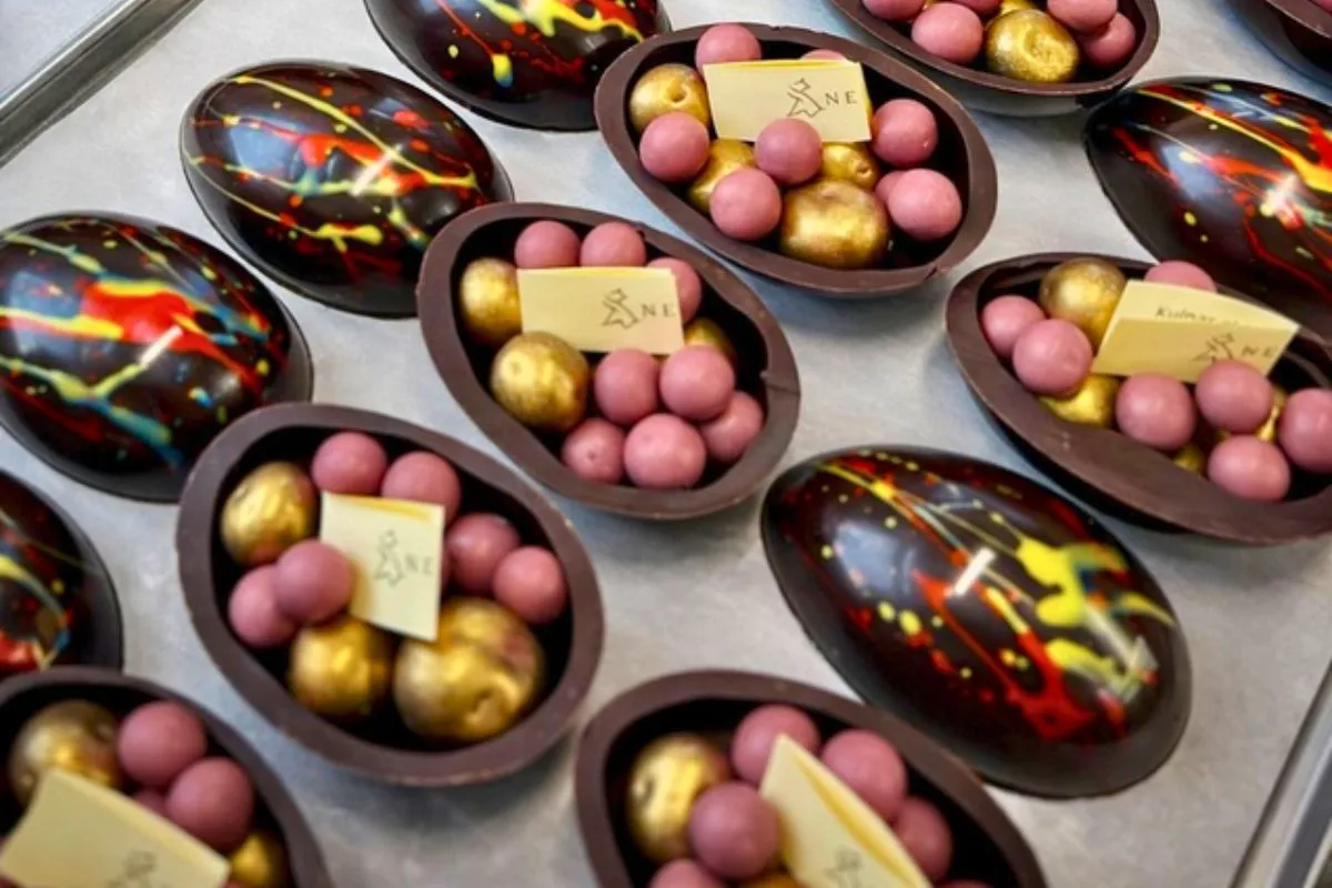 Neskja - Chocolate Confectionery's artisan dark chocolate halves filled with pink and gold bonbon.