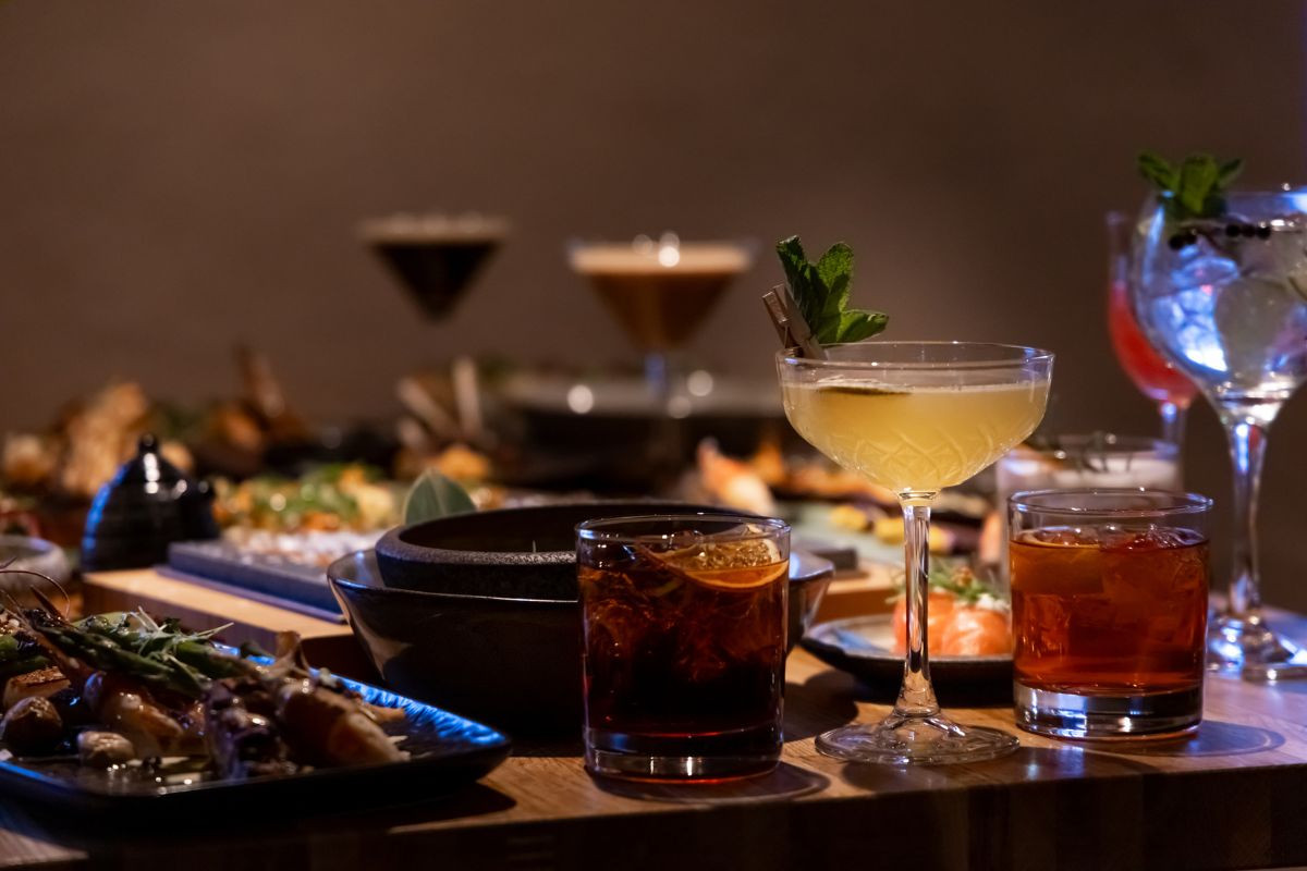 Craft cocktails and gourmet dishes on a table at Rub23 restaurant.