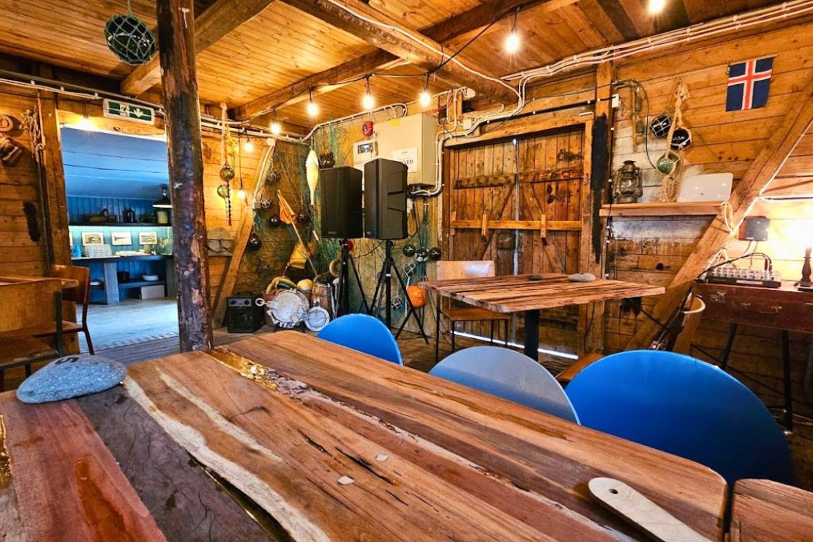Cozy rustic wooden interior with bright blue chairs at The Bait Shack bar.