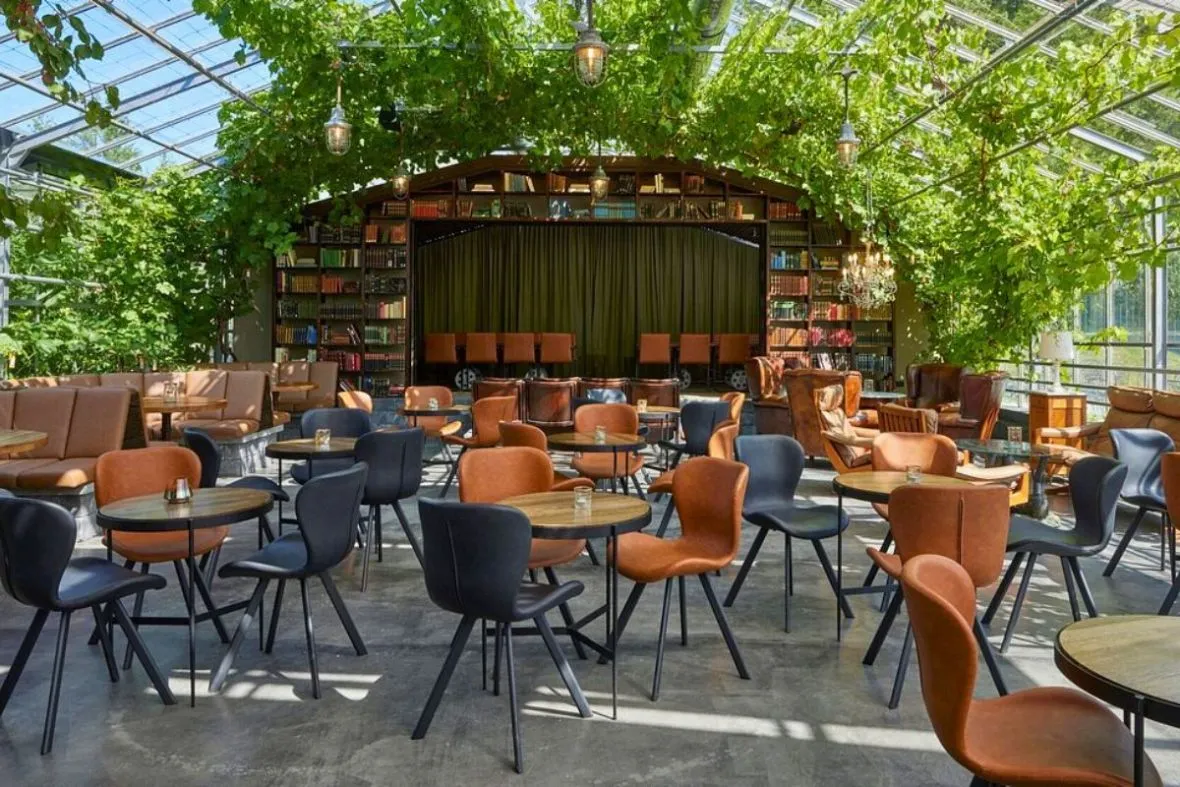 Cozy seating area under a canopy of grapevines inside Vínstofa Friðheima winebar in Reykholt, recommended by Handpicked Iceland.