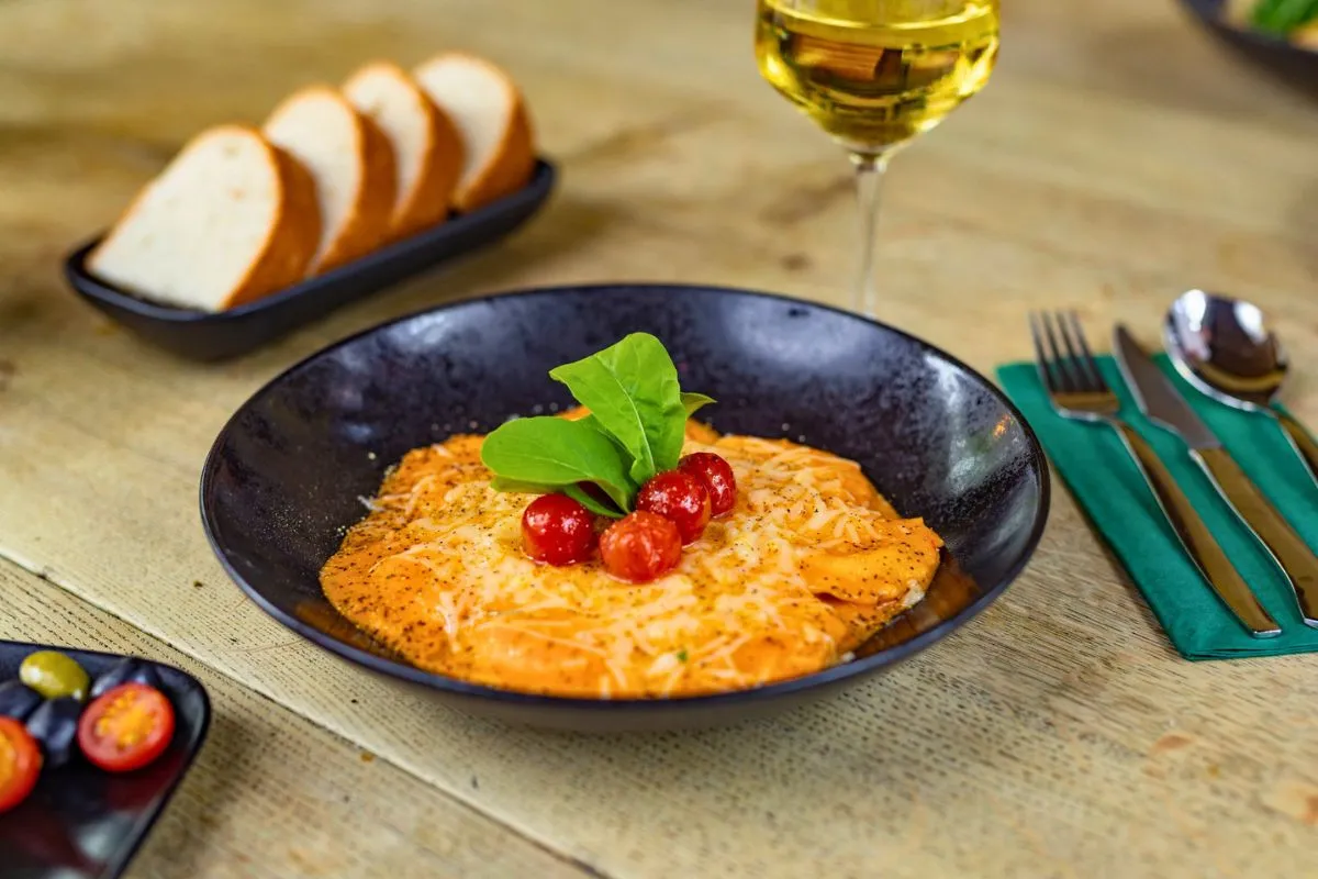 Fresh pasta dish topped with melted cheese and roasted tomatoes served at Friðheima restaurant.