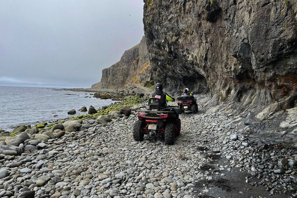West Wild Rocky quad bikes driving over a rocky stone beach during a guided tour.