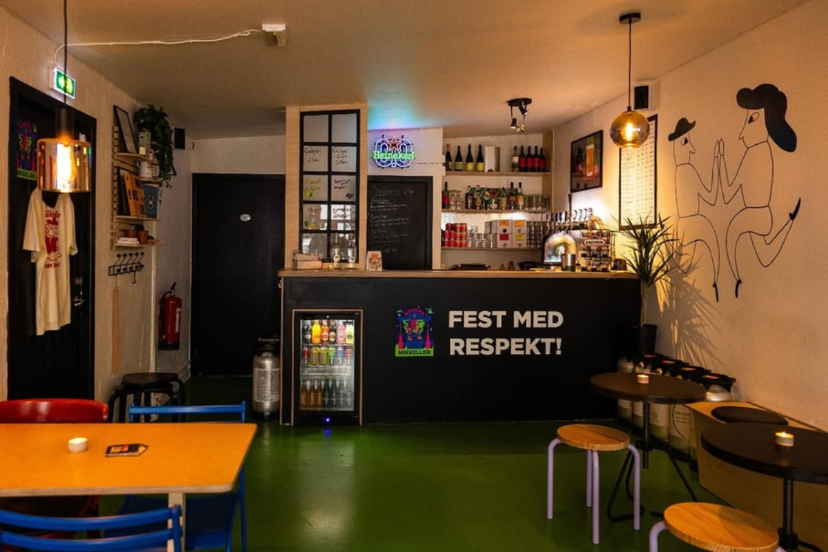 Bar counter with green flooring and mural at Bakken RVK in Reykjavík