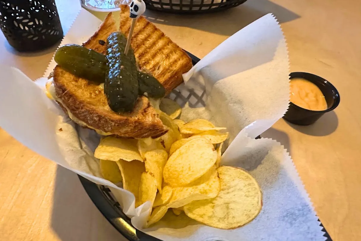 Grilled ham and cheese sandwich with potato chips at Bakken RVK