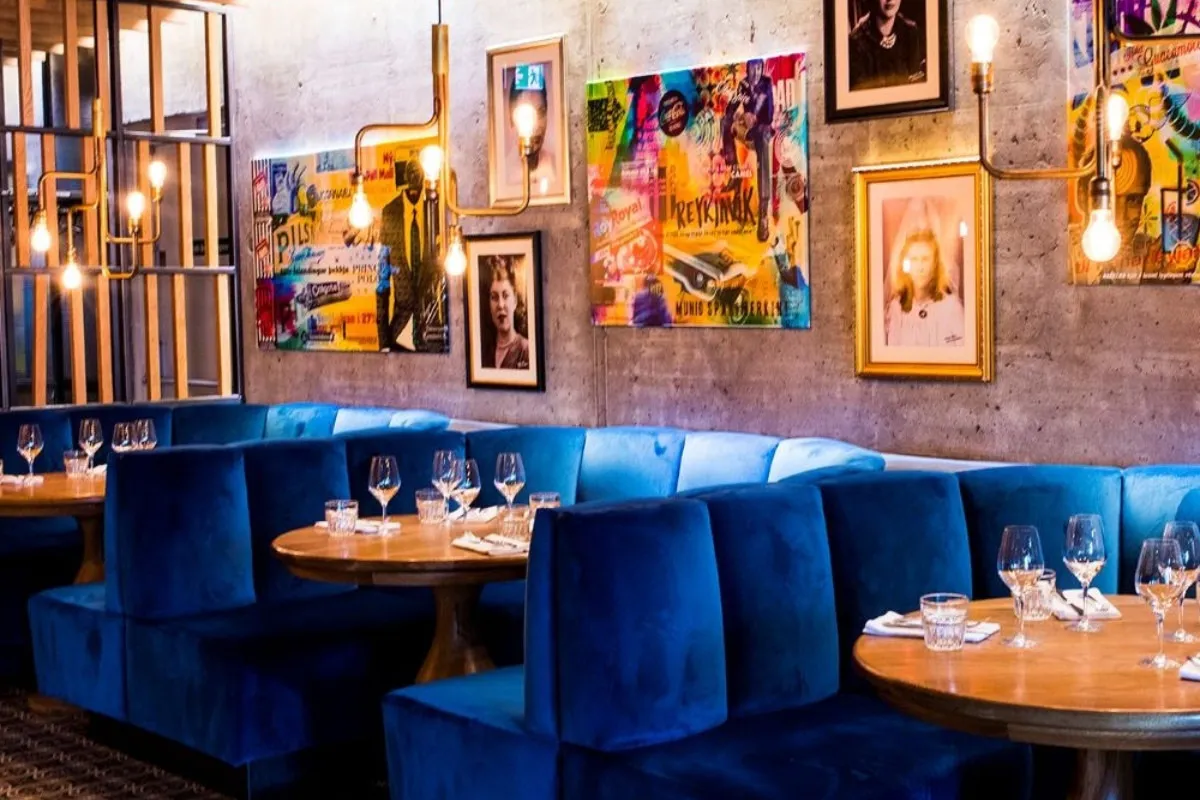Dining room with blue velvet booths at Geiri Smart Restaurant in Reykjavík, recommended by Handpicked Iceland