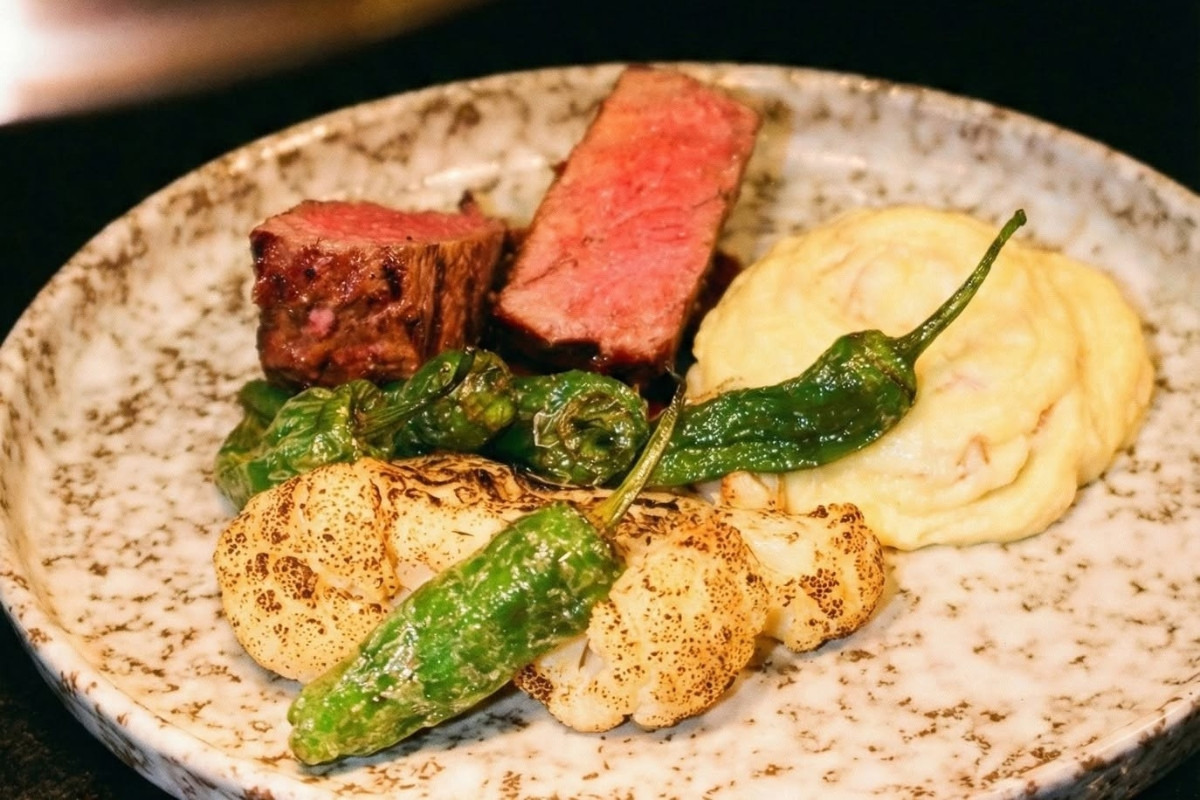 Sliced steak with mashed potatoes and vegetables