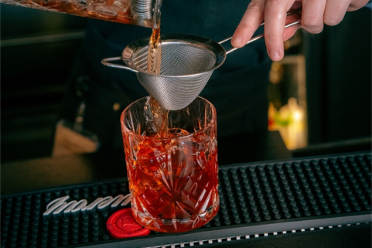 Bartender preparing a red cocktail